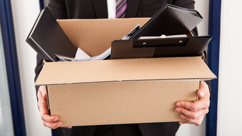 Fired worker carrying cardboard box