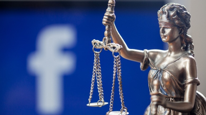 Justice statue in front of Facebook logo