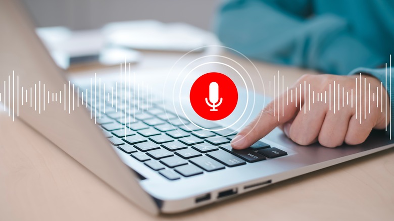 A silver laptop with microphone icon