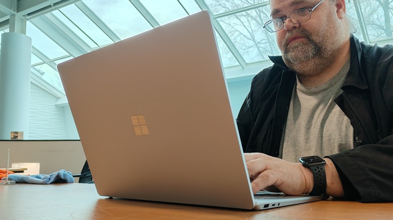 Man typing on Surface Laptop 5