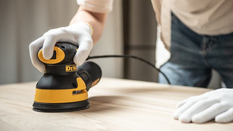 Using a DeWalt polisher on wooden table