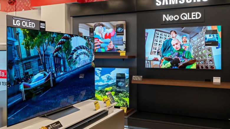 Samsung QLED TVs and LG OLED display inside electronics store