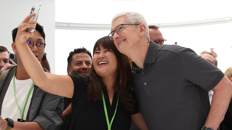 Woman taking a selfie with Tim Cook