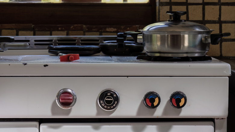 Close-up view of a vintage range with a stainless steel cooking pot and a lighter on top of it, in a farm house near the colonial town of Villa de Leyva, in central Colombia.