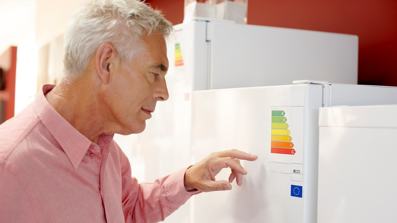 A man looking at freezers in an electrical shop