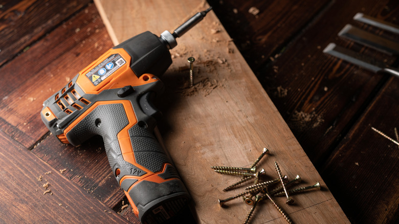 Cordless drill and screws on a piece of wood