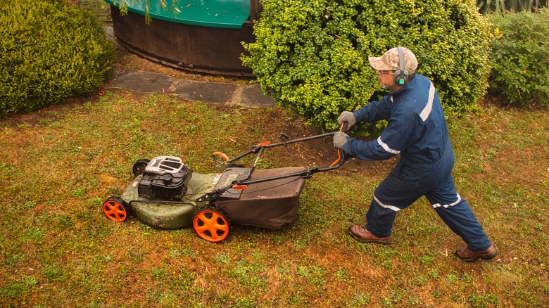 Man mowing grass in autumn