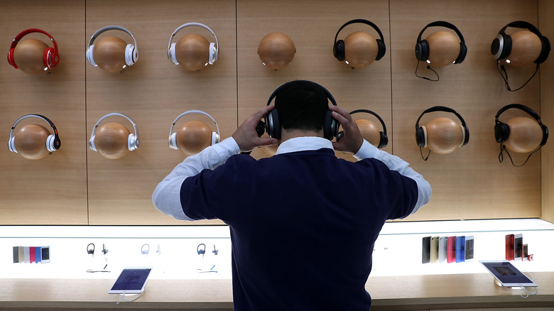 A man looking at different Bluetooth headphones 
