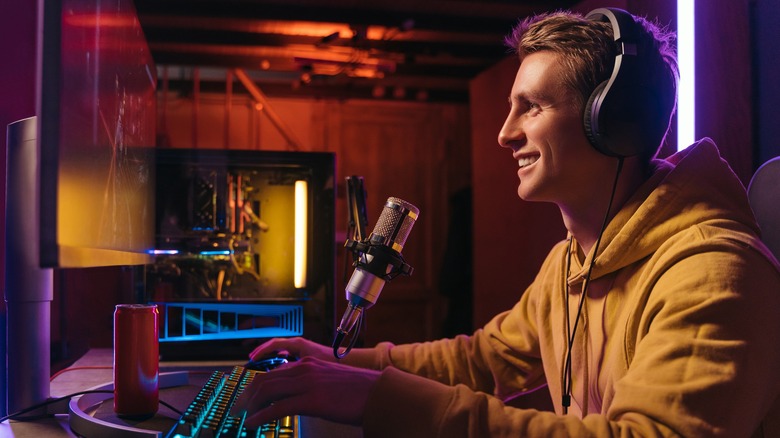 A man using a wired pair of headphones at his desk 