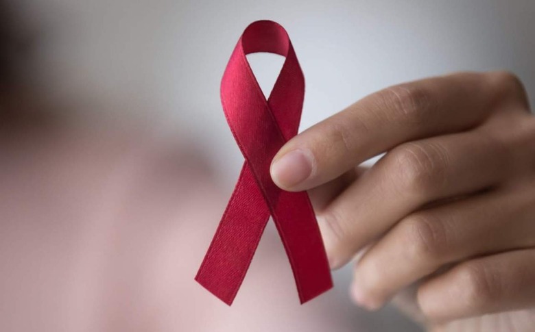 Person holding red ribbon