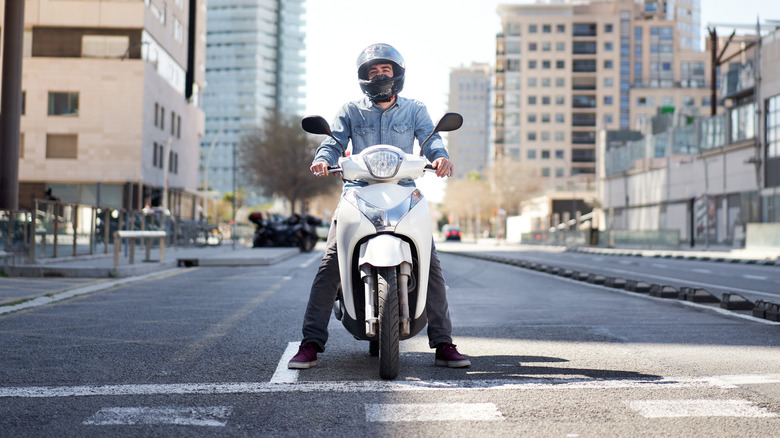 Person on a white scooter on a city street