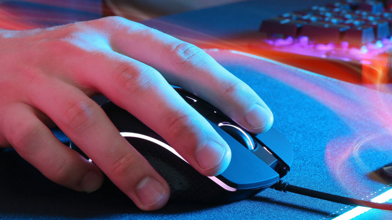 A person with their hand gripping a gaming mouse.