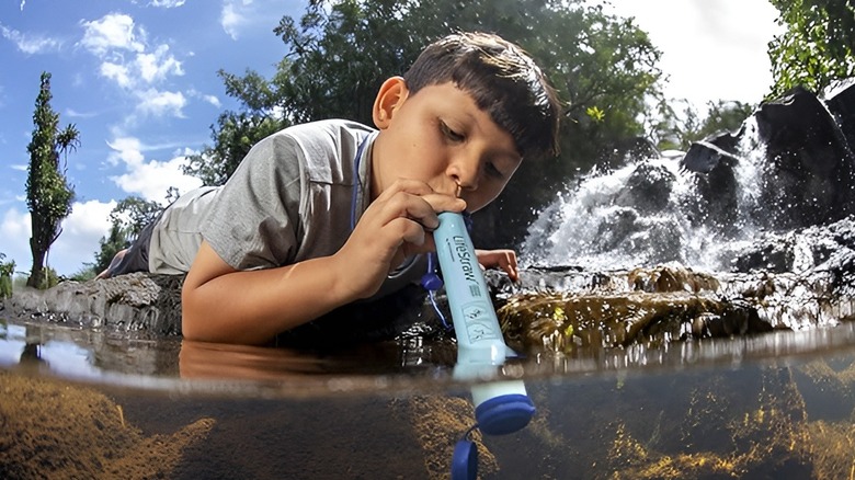 Kid drinking out of pond