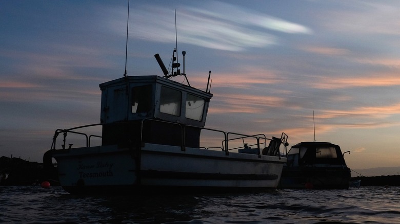 ship on water with nacreous clouds in the air