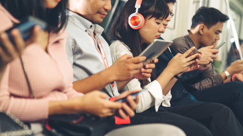 People using smartphones on subway