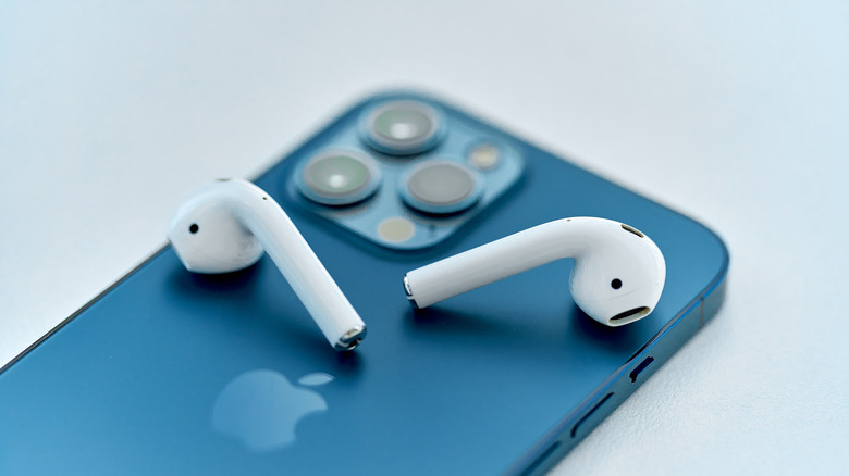 Apple AirPods placed on a blue iPhone