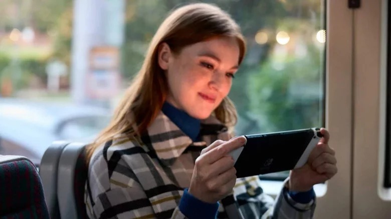 Woman playing Nintendo Switch OLED