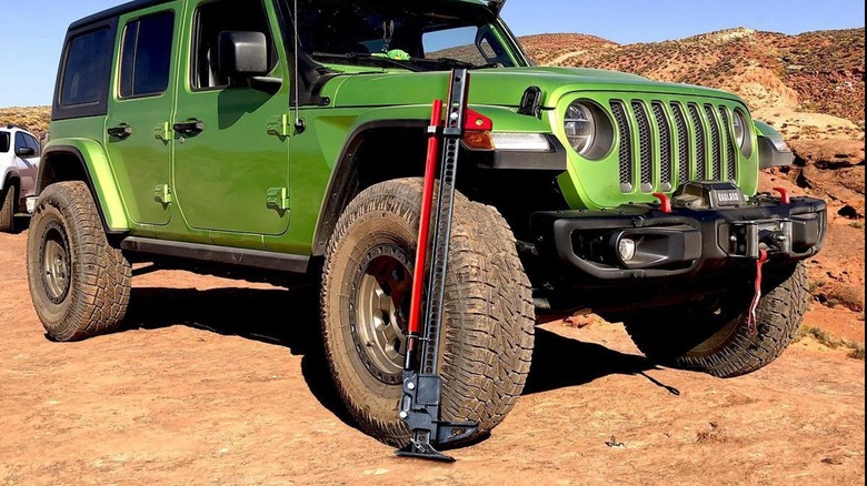 Off-road jack next to a Jeep tire