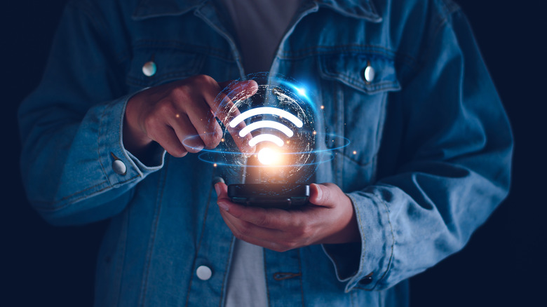 Man holding phone with Wi-Fi symbol