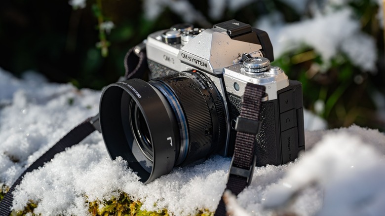 The OM System OM-3 on a snowy wall.