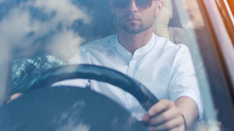 A man driving a car with no seat belt