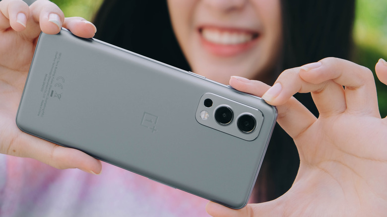 Woman using a OnePlus Nord smartphone to click photos.