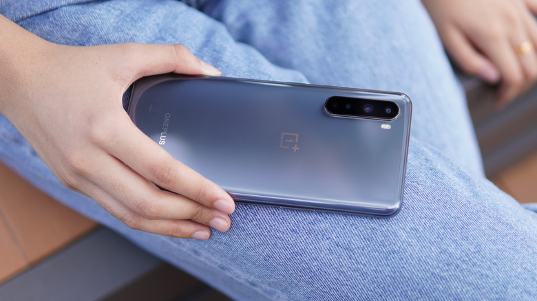 A woman holding the first-generation OnePlus Nord.