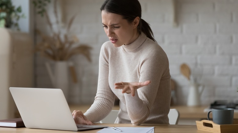 irritated person looking at laptop