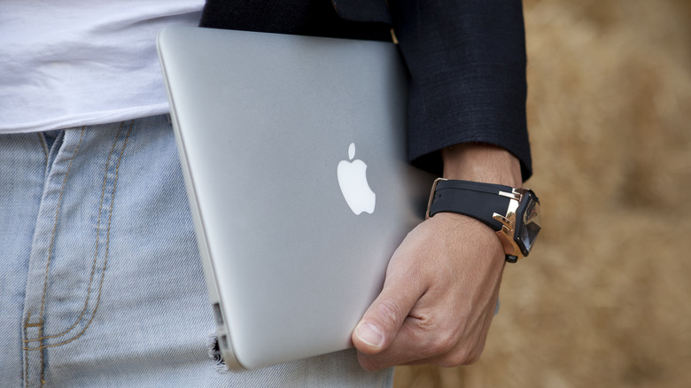 person carrying MacBook Air