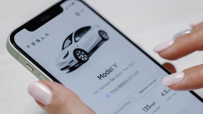 Woman looking at Model Y on phone