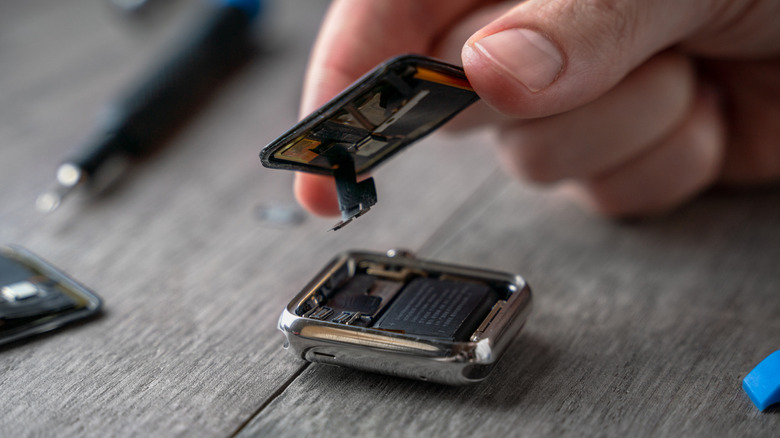 Person taking out the display assembly of an Apple Watch