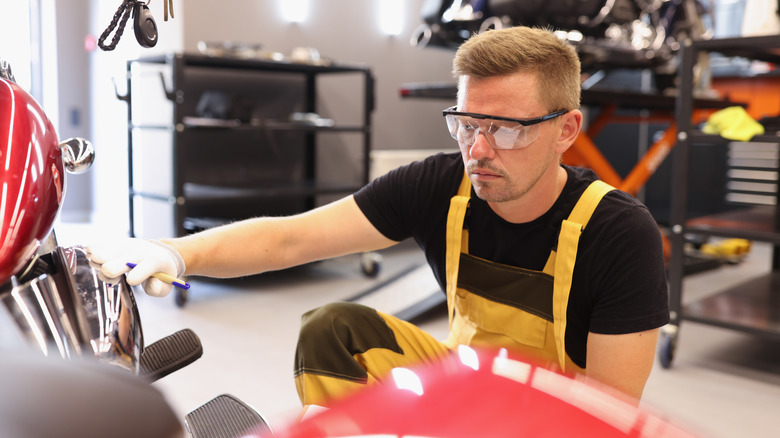 Mechanic looking at motorcycle