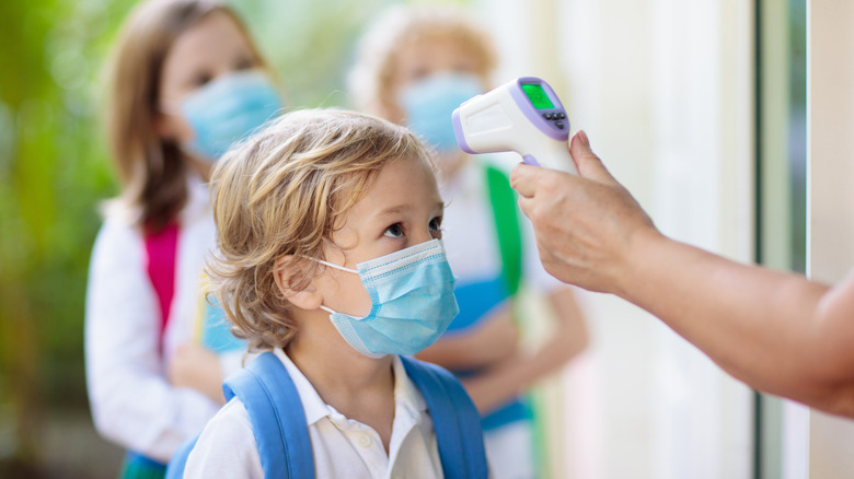 Temperature check of masked kid