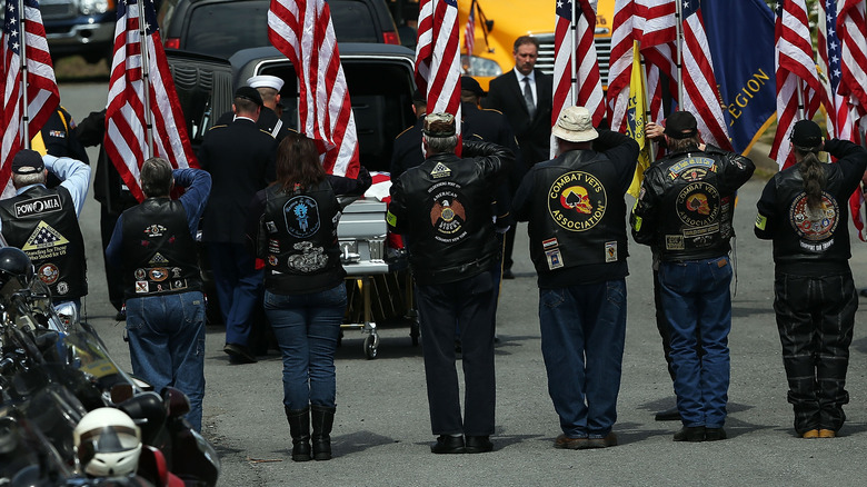 Patriot Guard Riders stand with flags at a funeral service