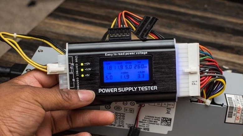 Power Supply Tester in man's hand