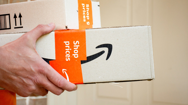 someone holding Amazon boxes