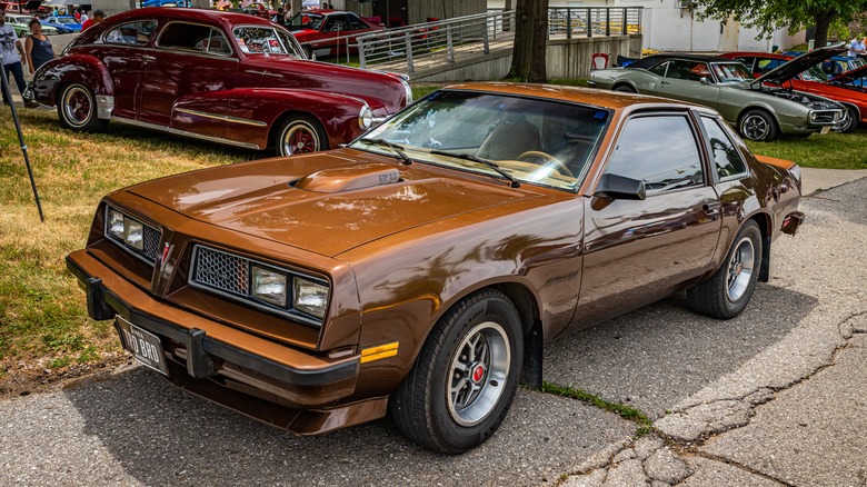 Golden Pontiac Sunbird in driveway