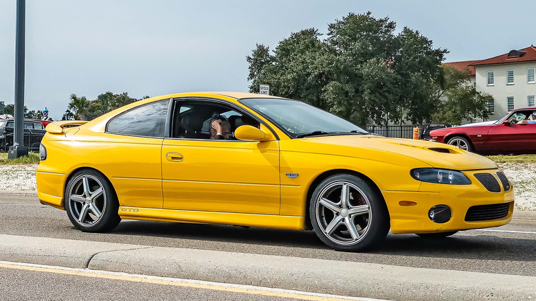 Yellow Pontiac GTO on road