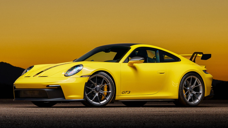 Porsche 992 GT3 front-left three-quarter view at sunset