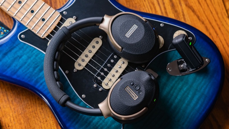 The Spark Neo on top of a blue Fender Stratocaster guitar with the wireless transmitter plugged in.