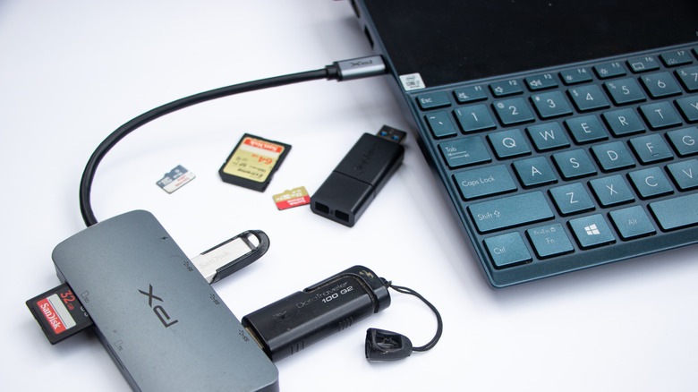 USB hub connected to a laptop with pen drive and SD card on the table