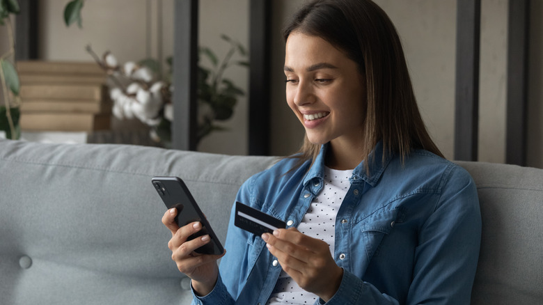 woman holding credit card and phone