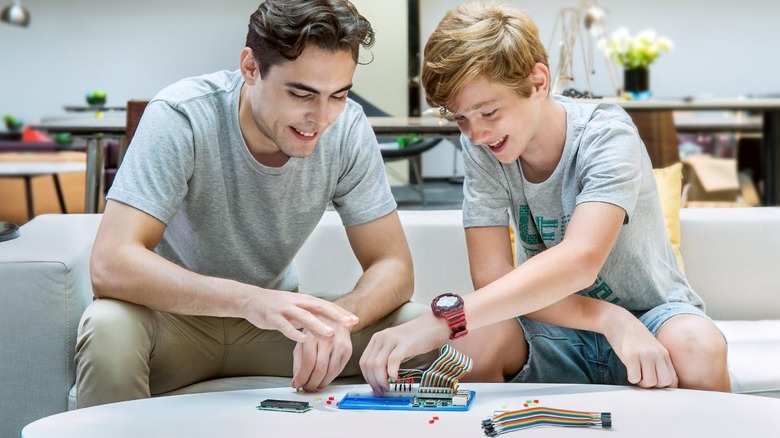 Young man and child using Raspberry Pi STEM kit