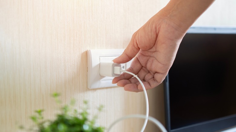 Smartphone charger being plugged into wall