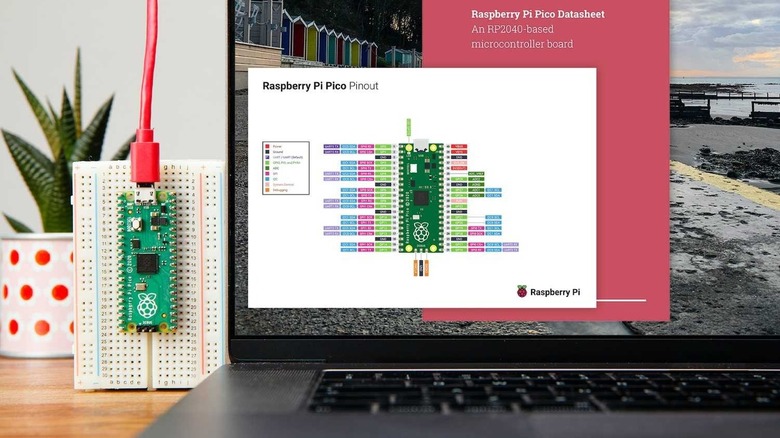 Raspberry Pi Pico on a breadboard next to laptop showing Pico documentation