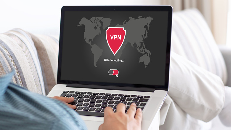 A man holding a laptop with a VPN icon on screen