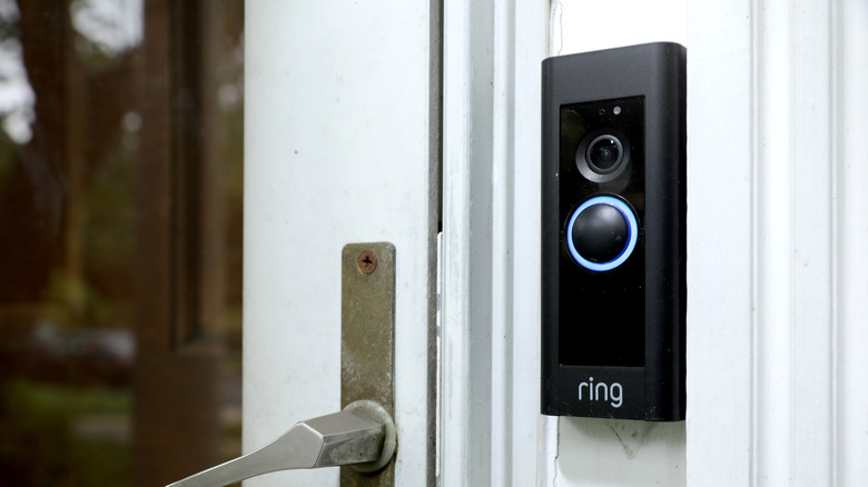 A Ring doorbell with a light around the bell button placed on a wall