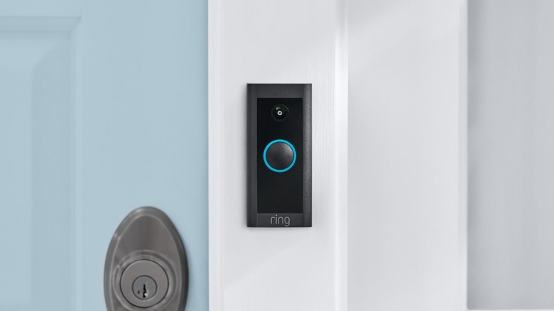 A Ring doorbell mounted on a white door frame