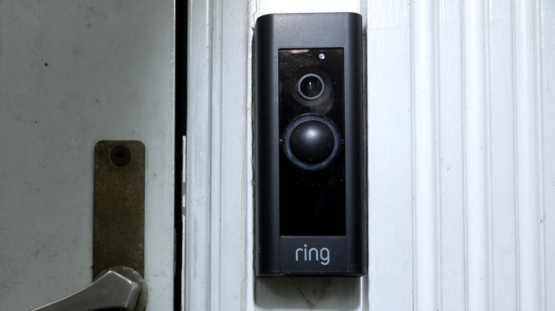 A Ring Video doorbell mounted on a white door frame