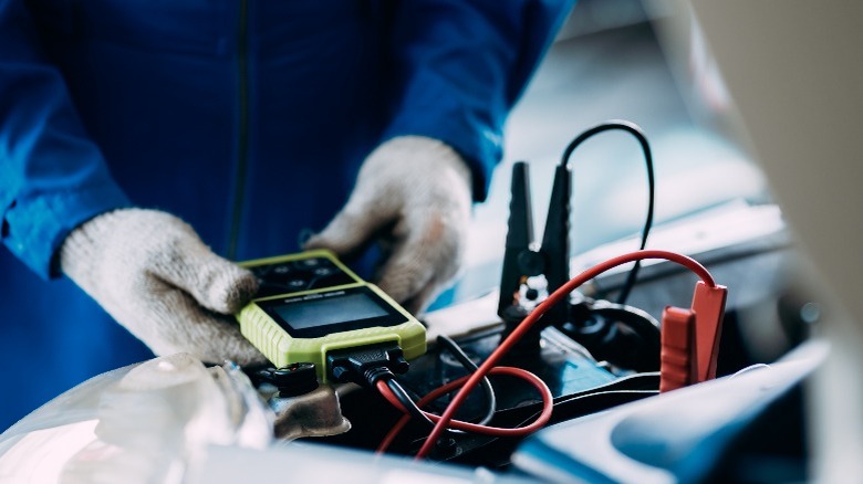 mechanic using battery tester